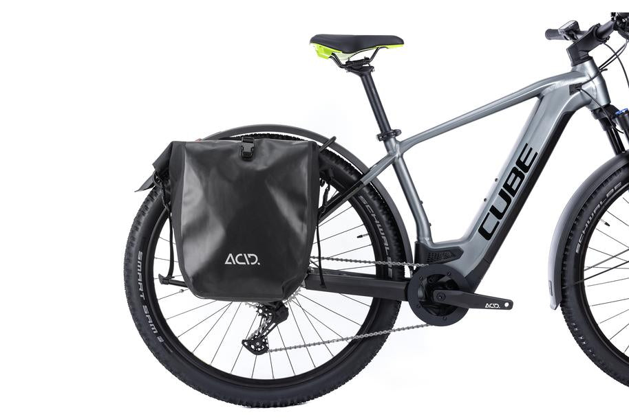 Ein graues CUBE E-Bike mit dem schwarzen ACID Gepäckträger SIC RAIL 29" und einer ACID Gepäcktasche in der Seitenansicht vor weißem Hintergrund - erhältlich in Ihrem CUBE Store in Hildesheim oder Goslar.