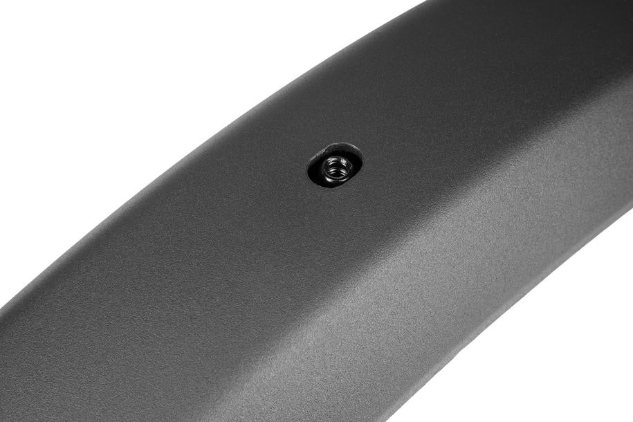 Nahaufnahme der glatten, gewölbten dunkelgrauen Oberfläche des ACID Schutzblechset SIC 2.0 84 27,5" BB Mount black von ACID, die eine kreisförmige Öffnung mit einer sichtbaren Metallfeder im Inneren zeigt - aufgenommen im CUBE Store Göttingen.