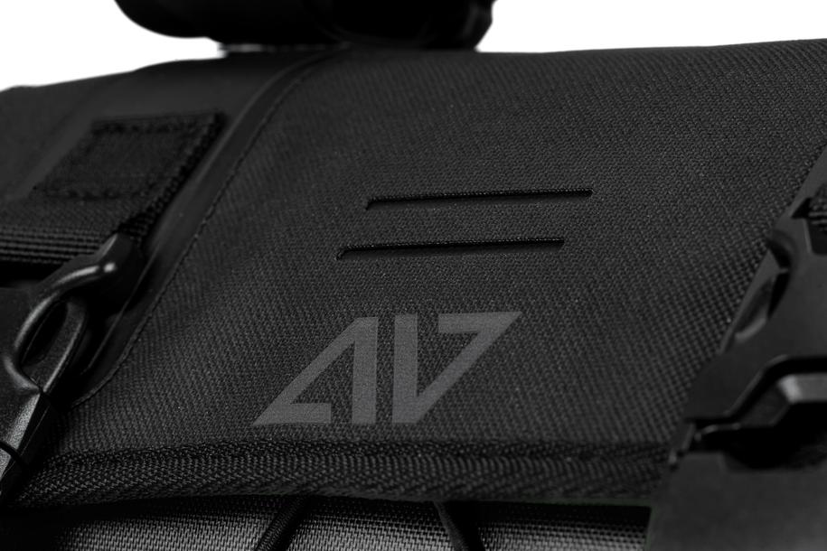Nahaufnahme der ACID Lenkertasche PACK PRO 15 black von ACID, mit schwarzem Stoff, sichtbarem Reißverschluss, Kunststoffclip und markantem Logo. Die Textur und die Nähte unterstreichen das hochwertige Design, das von der niedersächsischen Handwerkskunst inspiriert ist.