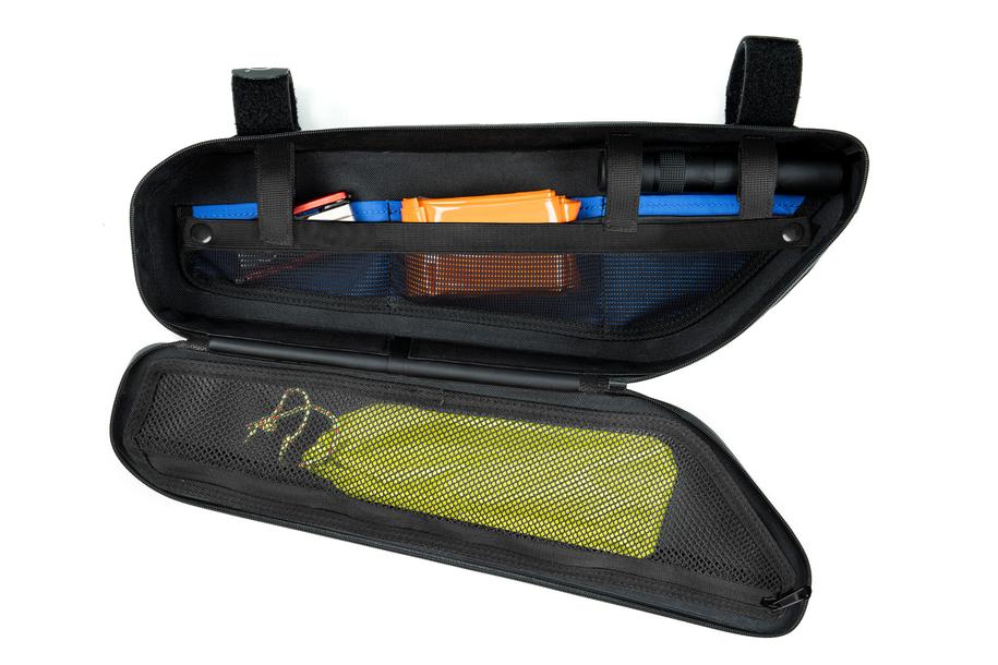 Die ACID Rahmentasche PACK PRO 2 black von ACID wird mit geöffnetem Reißverschluss gezeigt, der Fächer mit einem blauen Werkzeug, einem orangefarbenen Gegenstand und anderen kleinen Utensilien sowie einen gelben Gegenstand in einer Netztasche auf der offenen Klappe offenbart.