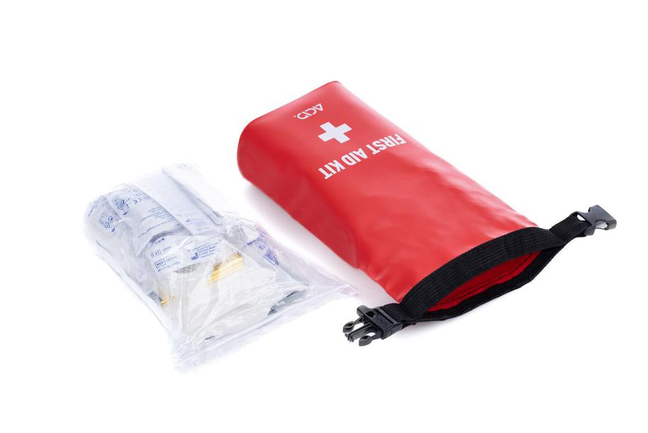 Das ACID Erste Hilfe Set PRO 29 von Cube, bestehend aus einer roten Tasche mit weißem Kreuz und FIRST AID KIT Aufschrift, wird mit einem durchsichtigen Beutel mit medizinischem Zubehör aus dem CUBE Store in Goslar, Niedersachsen, auf weißem Hintergrund gezeigt.