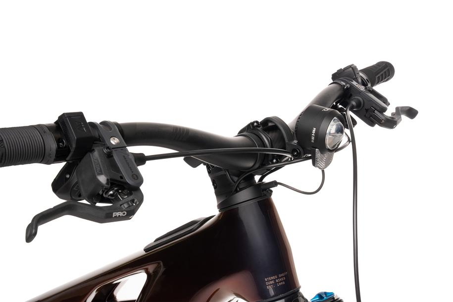 Nahaufnahme eines Fahrradlenkers mit Bremshebeln, Gangschaltung, Kabeln und dem ACID E-Bike Frontlicht PRO-E 200 High Beam X-Connect von ACID (150 Lux/440 Lumen, StVZO-zertifiziert), alles vor einem weißen Hintergrund.