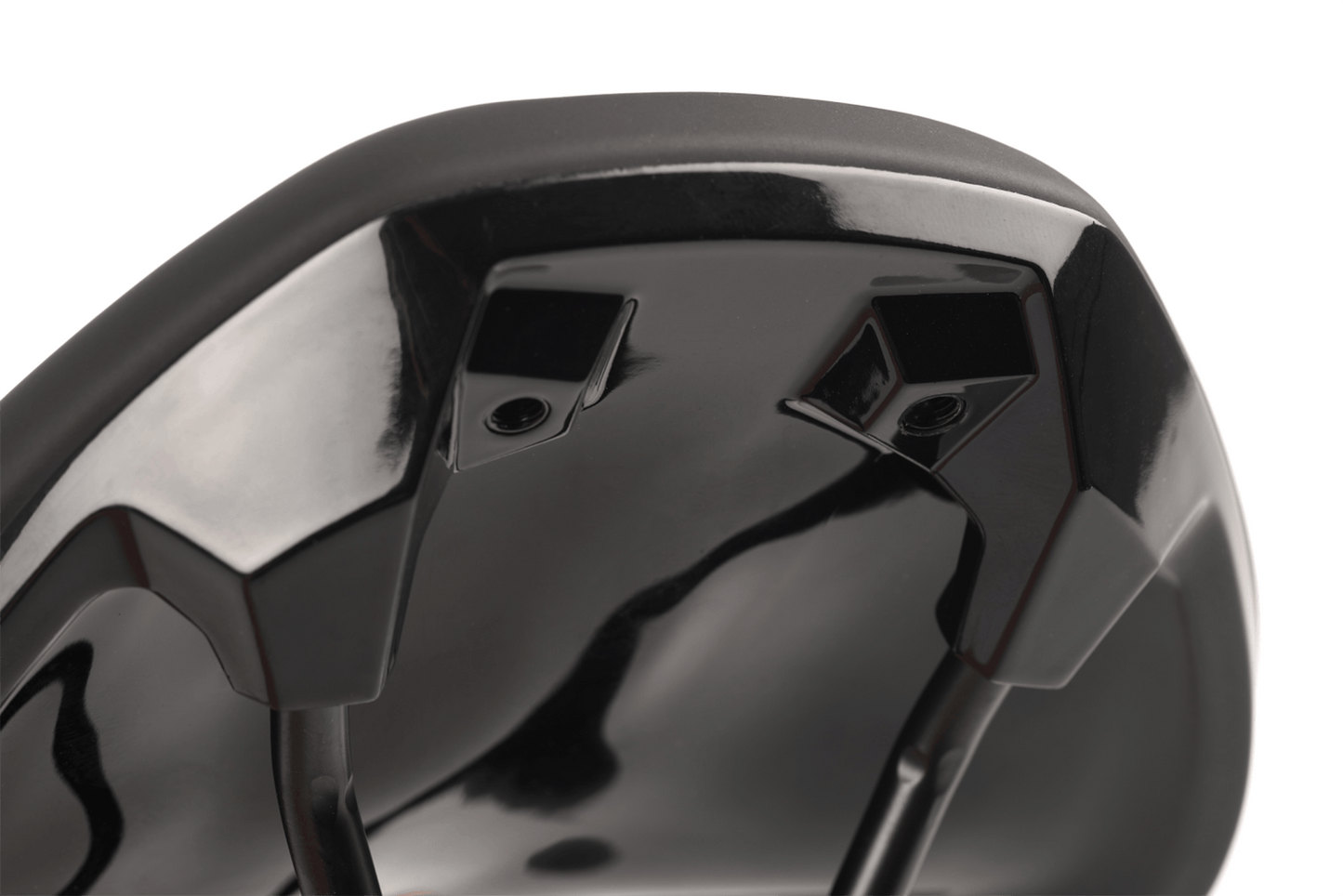 Die Nahaufnahme der Unterseite des Natural Fit Sattel Sequence+ Regular zeigt die schwarz glänzende Oberfläche, die Montagebügel und die Schienen. Die spiegelnde Oberfläche hebt die ergonomische Designline und die Deep-Shell Sattelschale für zusätzlichen Komfort hervor.