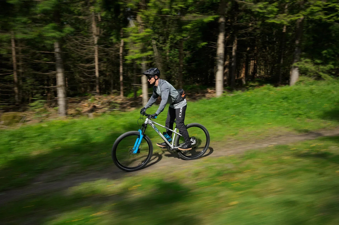 Mountainbiker fährt schnell auf einem CUBE Hardtail-Mountainbike über einen Waldtrail