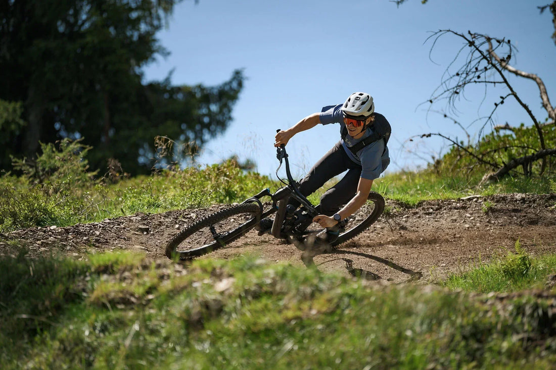 Mountainbiker fährt in Schräglage durch eine Kurve auf einem CUBE Fully-Mountainbike im Gelände
