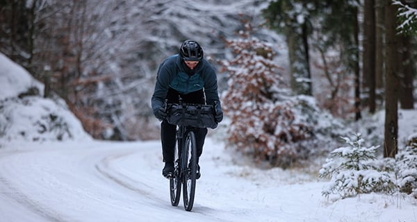 Radfahrer im Winter auf schneebedeckter Straßee