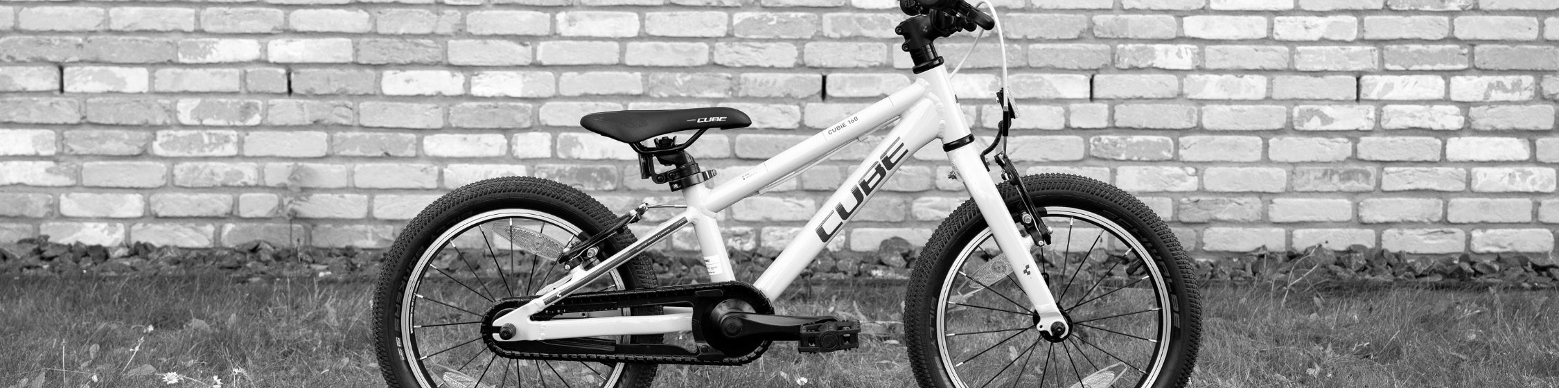 Kinderfahrrad vor Backsteinwand