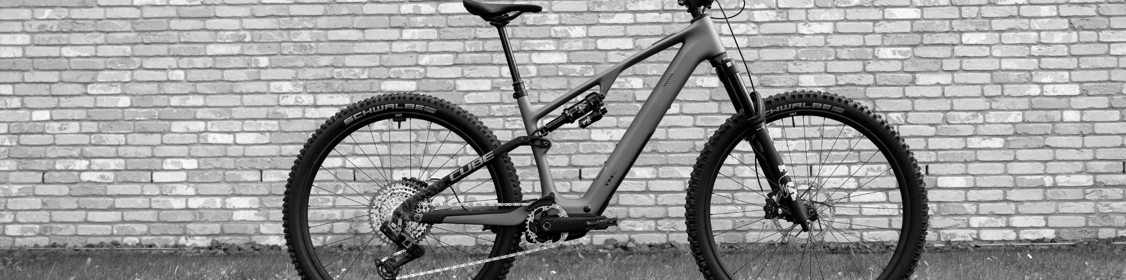 E Mountainbike vor Backsteinwand 