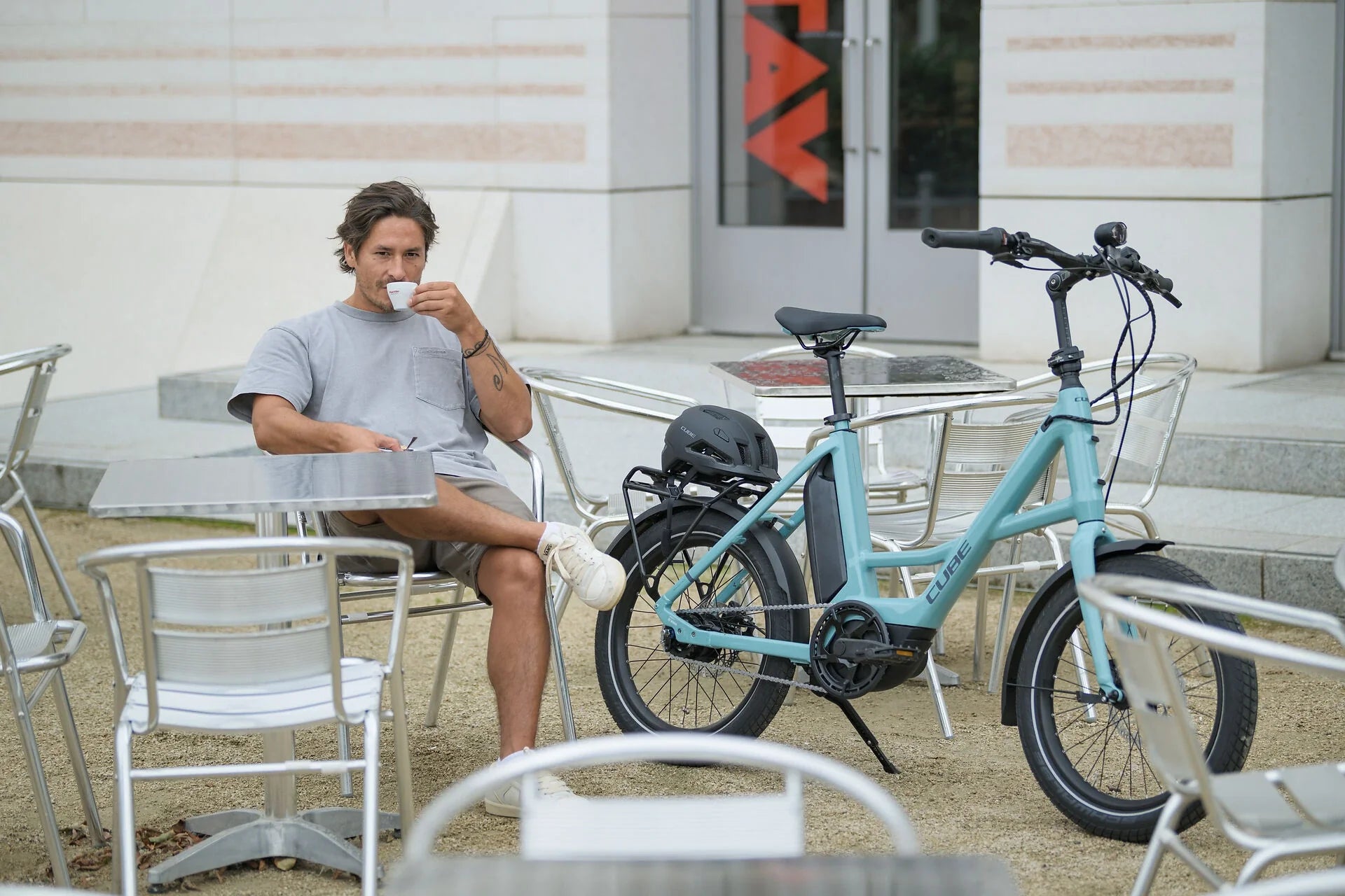 CUBE Compact Hybrid E-Bike 20 Zoll – Mann im Cafe mit kompaktem City-Pedelec