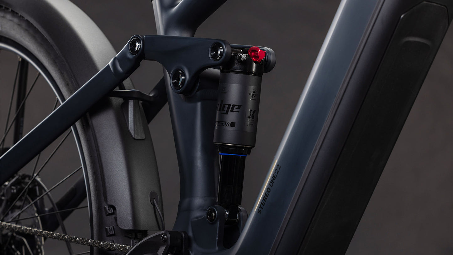 Nahaufnahme der Hinterradaufhängung des CUBE Stereo Hybrid ONE22 Pro 800 FE night'n'chrome 2026, die den Stoßdämpfer, den matten dunkelgrauen Rahmen, die technischen Komponenten und den leistungsstarken Bosch CX Motor zeigt.