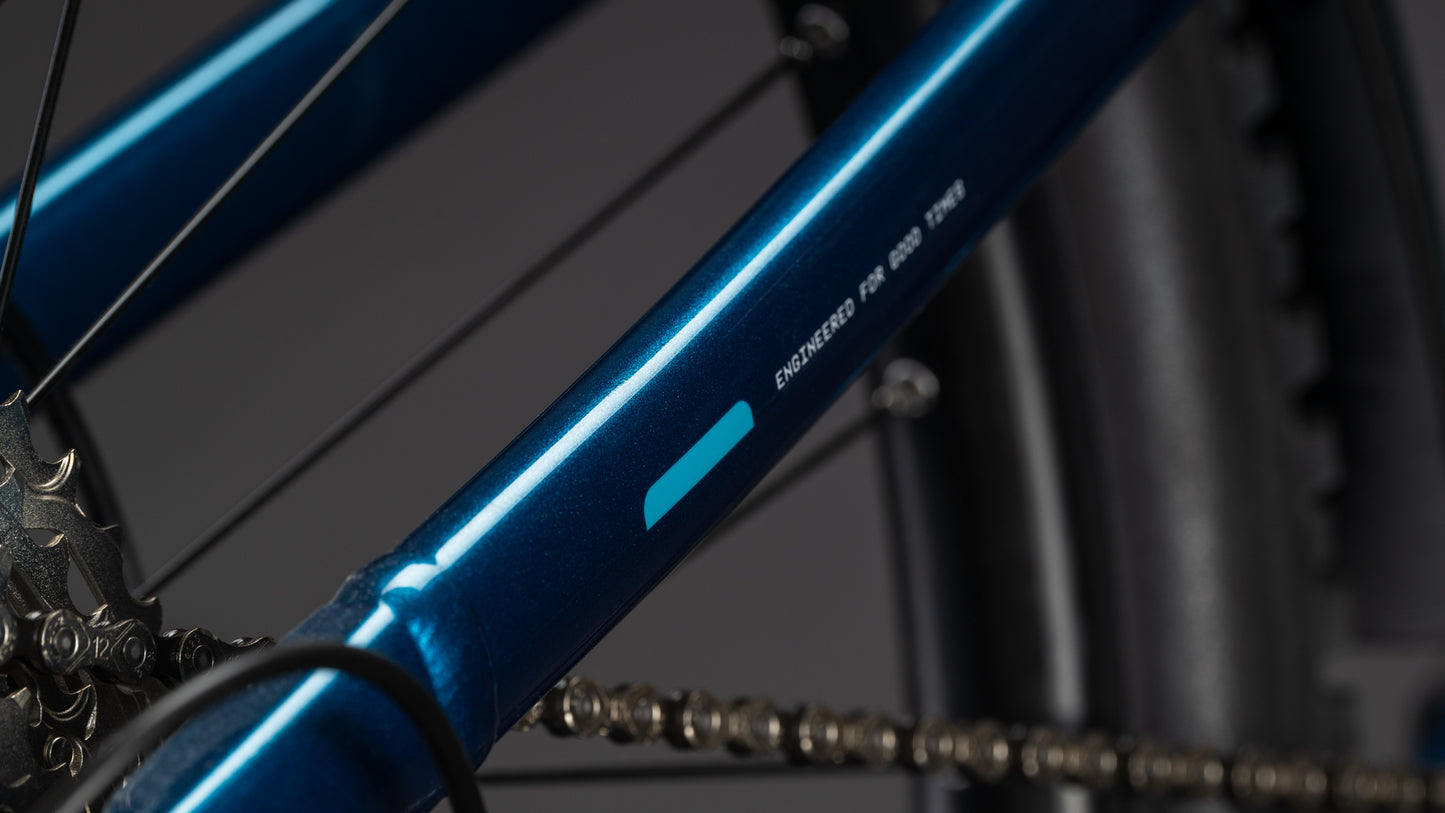 Nahaufnahme des Cube Stereo Hybrid ONE22 Race 800 electricblue'n'white 2026 von CUBE. Hervorzuheben sind der metallisch blaue Rahmen, die Kette, das Hinterrad, ENGINEERED FOR ANYWHERE auf dem Oberrohr und die Shimano XT Schaltung für präzise Schaltvorgänge.