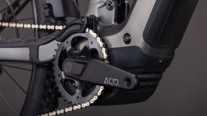 Nahaufnahme von Pedal, Kettenblatt und Kette des CUBE Stereo Hybrid ONE22 Race 800 FE slabgrey'n'chrome 2026. Der ACID-Kurbelarm hebt sich von einem mattschwarzen und grauen Rahmen ab, in dem ein Bosch CX-Motor für kraftvolle Fahrten sorgt.