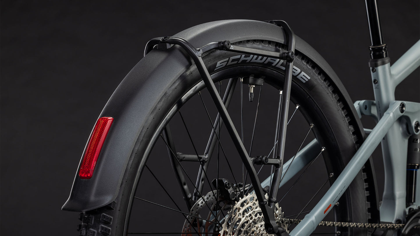 Nahaufnahme des Hinterrads des CUBE Stereo Hybrid ONE44 Pro 800 FE vulcan'n'orange 2026. Zu sehen sind ein schwarzes Schutzblech mit rotem Reflektor, Schwalbe-Reifen, Schaltkassette und ein Teil des hellblauen E-Bike-Rahmens vor einem dunklen Hintergrund.