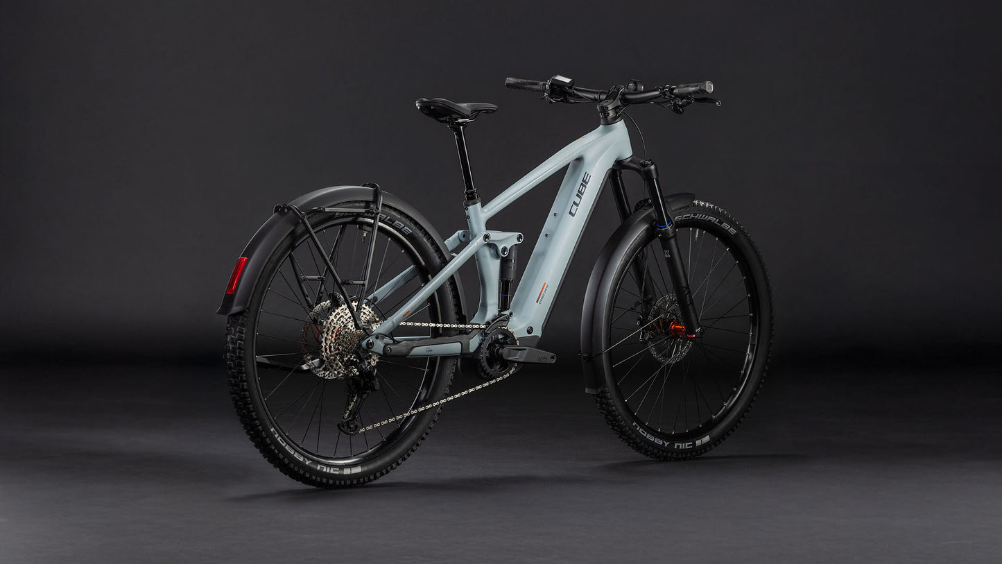 Das CUBE Stereo Hybrid ONE44 Pro 800 FE vulcan'n'orange 2026 E-Bike verfügt über dicke schwarze Reifen, einen Bosch CX-Motor, Scheibenbremsen, eine sichtbare Schaltung, ein hinteres Schutzblech und einen schlanken Rahmen auf dunklem Hintergrund.