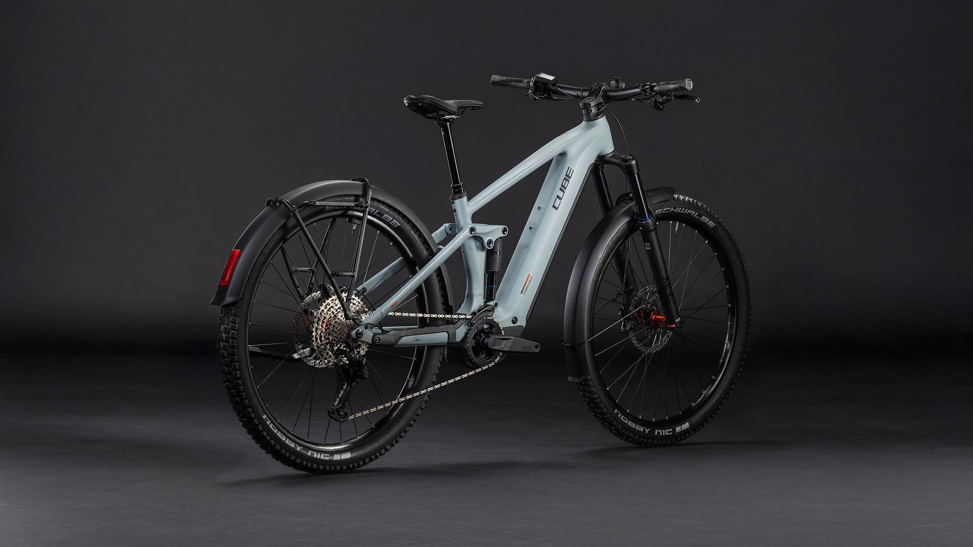 Das CUBE Stereo Hybrid ONE44 Pro 800 FE vulcan'n'orange 2026 E-Bike verfügt über dicke schwarze Reifen, einen Bosch CX-Motor, Scheibenbremsen, eine sichtbare Schaltung, ein hinteres Schutzblech und einen schlanken Rahmen auf dunklem Hintergrund.