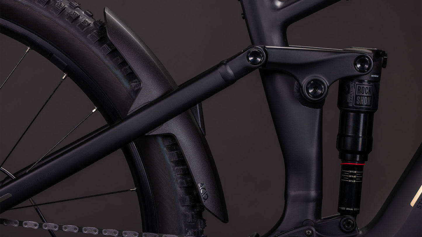 Die Nahaufnahme des CUBE Stereo Hybrid ONE44 EX 800 blackline 2026 zeigt den mattschwarzen Rahmen, die Hinterradfederung mit RockShox-Dämpfer, den Bosch CX-Antrieb und das Schutzblech oberhalb des Rades.