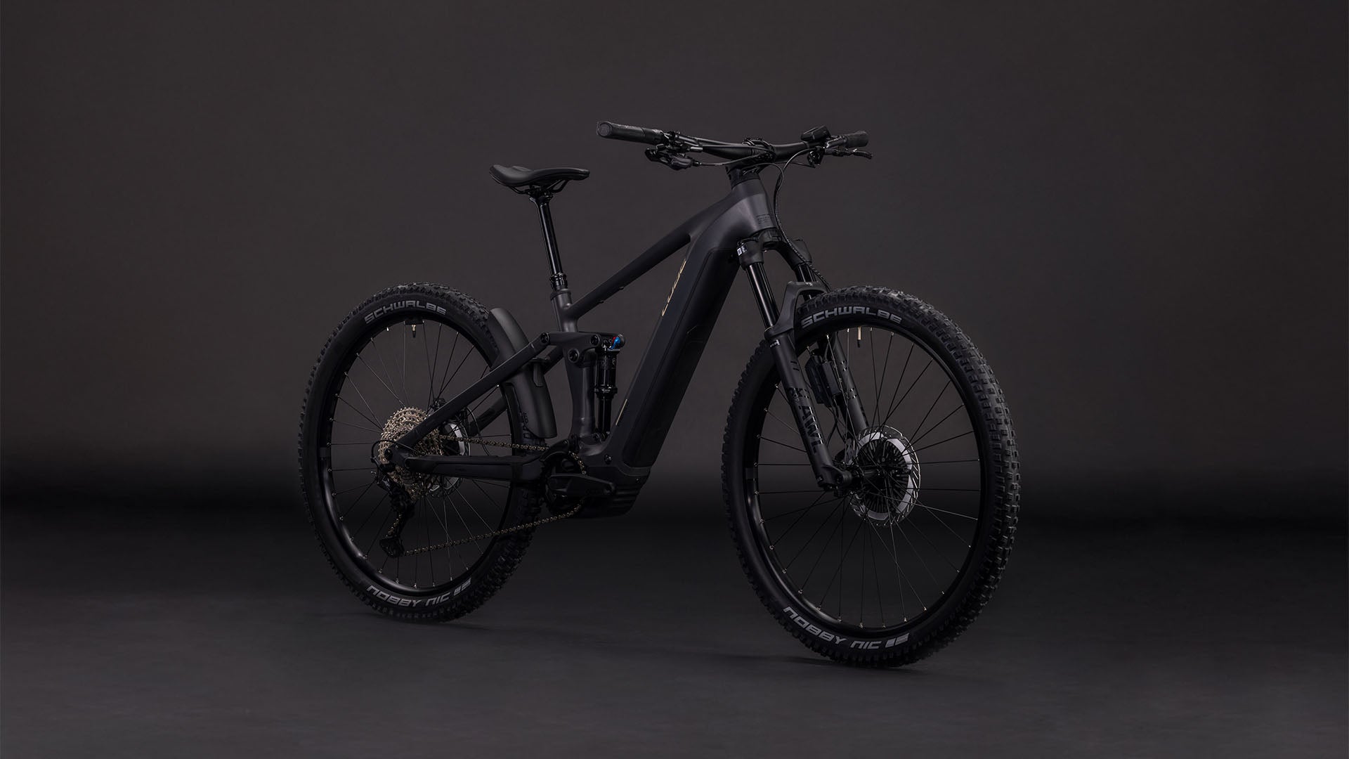 Das CUBE Stereo Hybrid ONE44 EXC 800 irongrey'n'chrome 2026, ein vollgefedertes Mountainbike mit Scheibenbremsen, dicken Reifen und einem Bosch CX Motor mit 800 Wh PowerTube Akku, wird vor einem dunklen, nahtlosen Hintergrund gezeigt.