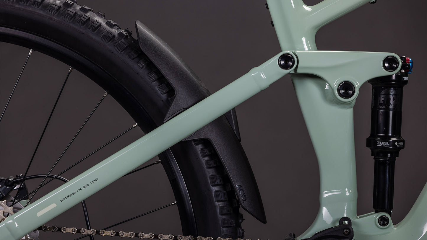 Nahaufnahme des hinteren Rahmens des CUBE Stereo Hybrid ONE44 EXC 800 desertstone'n'driedherbs 2026, die die hintere Federung, den Stoßdämpfer und das schwarze Schutzblech zeigt. Dieses E-Mountainbike ist mit einem Bosch CX-Motor ausgestattet und steht vor einem schlichten dunklen Hintergrund.
