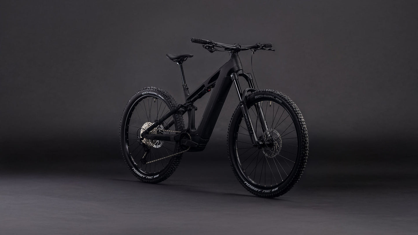 Das CUBE Stereo Hybrid ONE44 HPC Race 800 blackline 2026 Elektro-Mountainbike mit robustem Carbonrahmen und breiten Reifen wird auf einem dunklen, nahtlosen Hintergrund präsentiert, der sein schlankes Design und seine leistungsstarke Bauweise unterstreicht.
