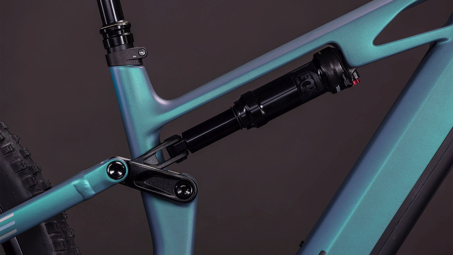Nahaufnahme des CUBE Stereo Hybrid ONE44 HPC Race 800 smaragdgrey'n'prism (2026) Rahmens mit Hervorhebung des hinteren Dämpfers und des Gestänges. Das mattblaue Gradienten-Finish sorgt für einen eleganten, hochwertigen Look vor einem dunklen Hintergrund.
