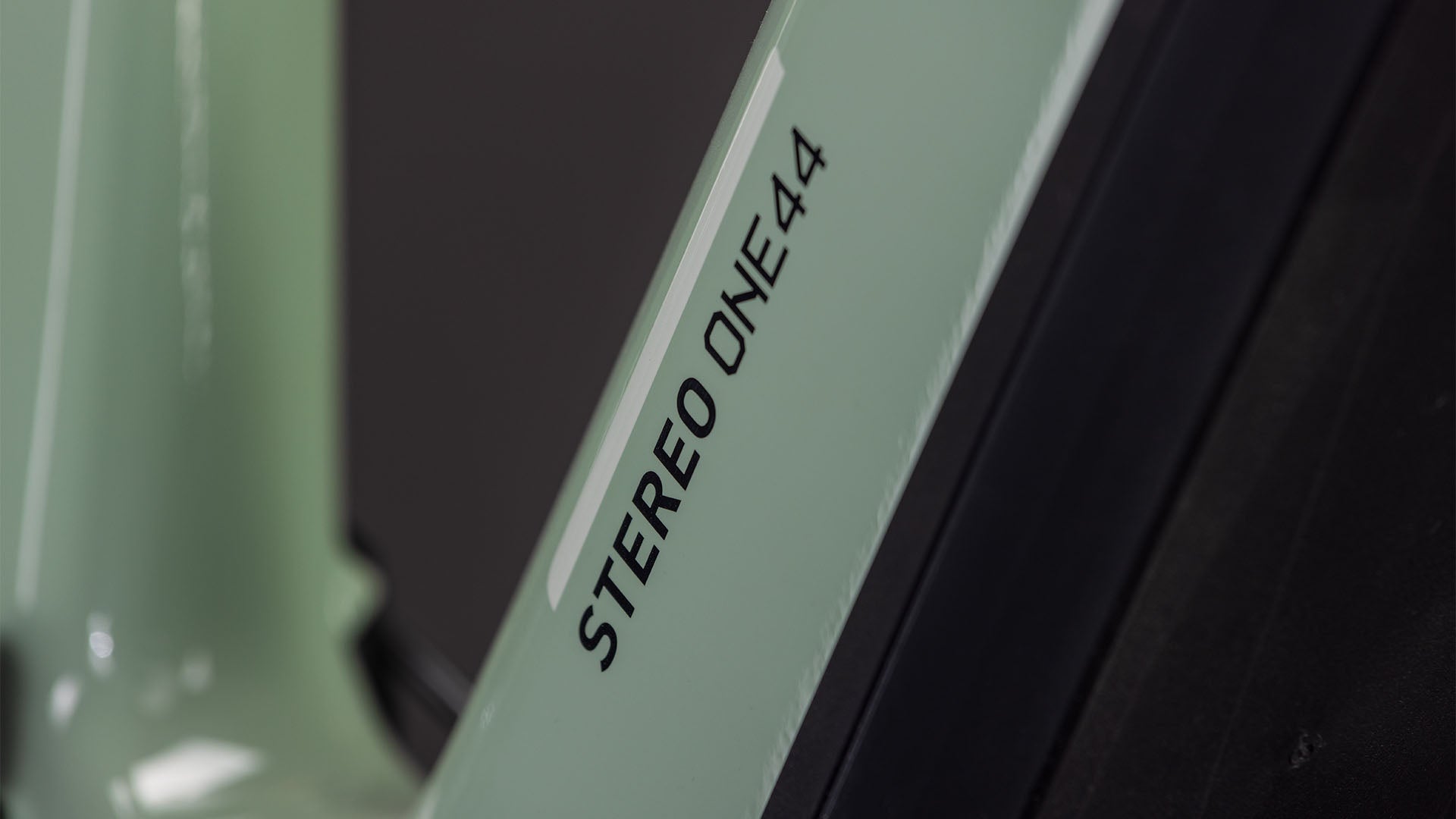 Nahaufnahme eines CUBE Stereo Hybrid ONE44 HPC Race 800 (2026) Rahmens in driedherbs'n'black mit dem Text "STEREO ONE44" in Schwarz auf der hellgrünen Oberfläche.