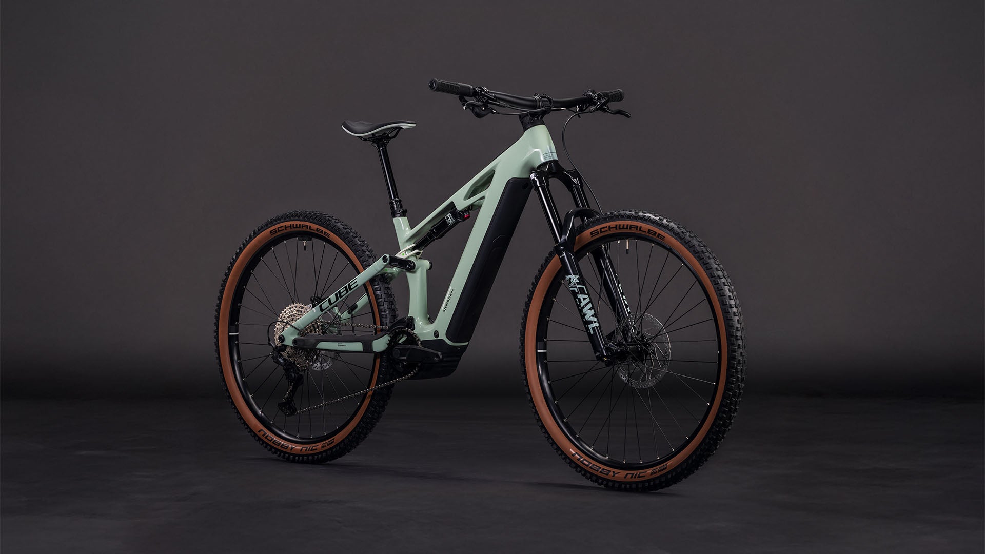 Das CUBE Stereo Hybrid ONE44 HPC Race 800 in driedherbs'n'black (2026) ist ein modernes Mountainbike mit breiten Stollenreifen, Vorderradfederung und einem leistungsstarken Bosch CX-Motor auf dunklem Grund.