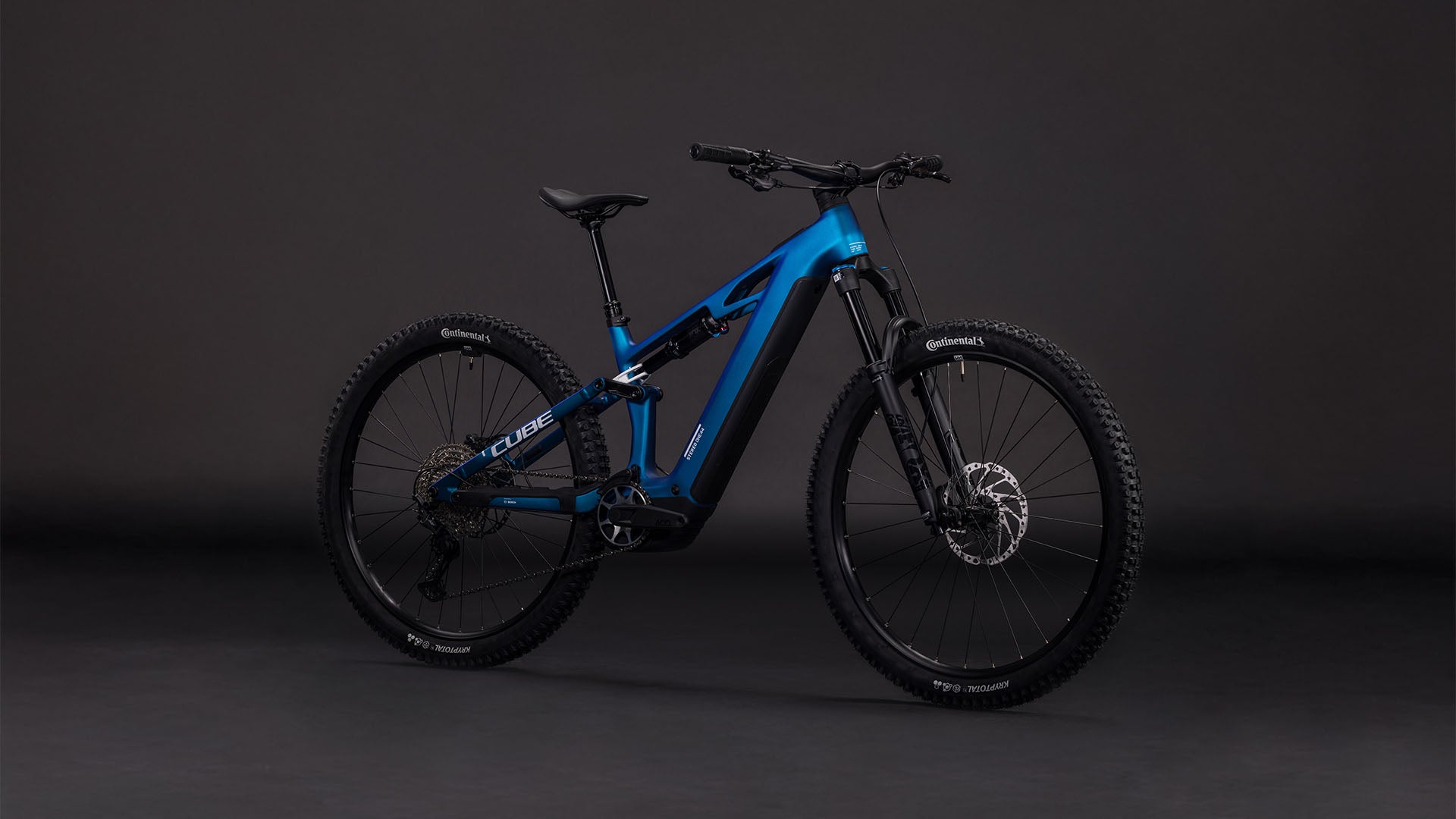 Das CUBE Stereo Hybrid ONE44 HPC SLX 800 nebula'n'white 2026 E-Bike verfügt über dicke Reifen, Scheibenbremsen, einen modernen Rahmen und einen leistungsstarken Bosch CX-Motor, der vor einem dunklen, neutralen Hintergrund steht.