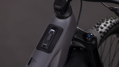 Nahaufnahme des mattgrauen Oberrohrs des CUBE Stereo Hybrid ONE77 HPC Race 800 irongrey'n'black 2026 mit eingebautem Bosch-Bedienfeld und Power-Knopf neben Lenker und Gabel, angetrieben von einem Bosch CX-Motor.