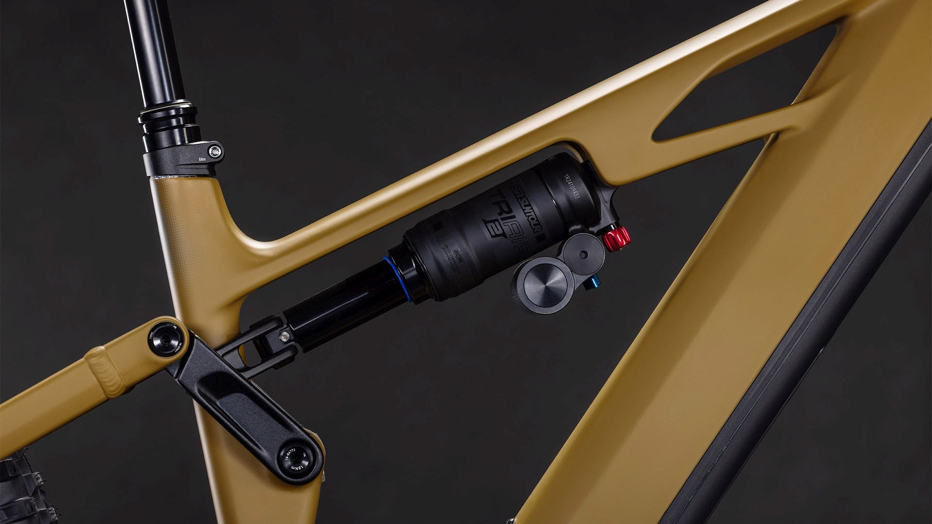 Nahaufnahme eines CUBE Stereo Hybrid ONE77 HPC Race 800 willowgreen'n'black 2026 Rahmens, die das hintere Federbein, das Gestänge und den Bosch CX Motor vor einem dunklen Hintergrund zeigt.