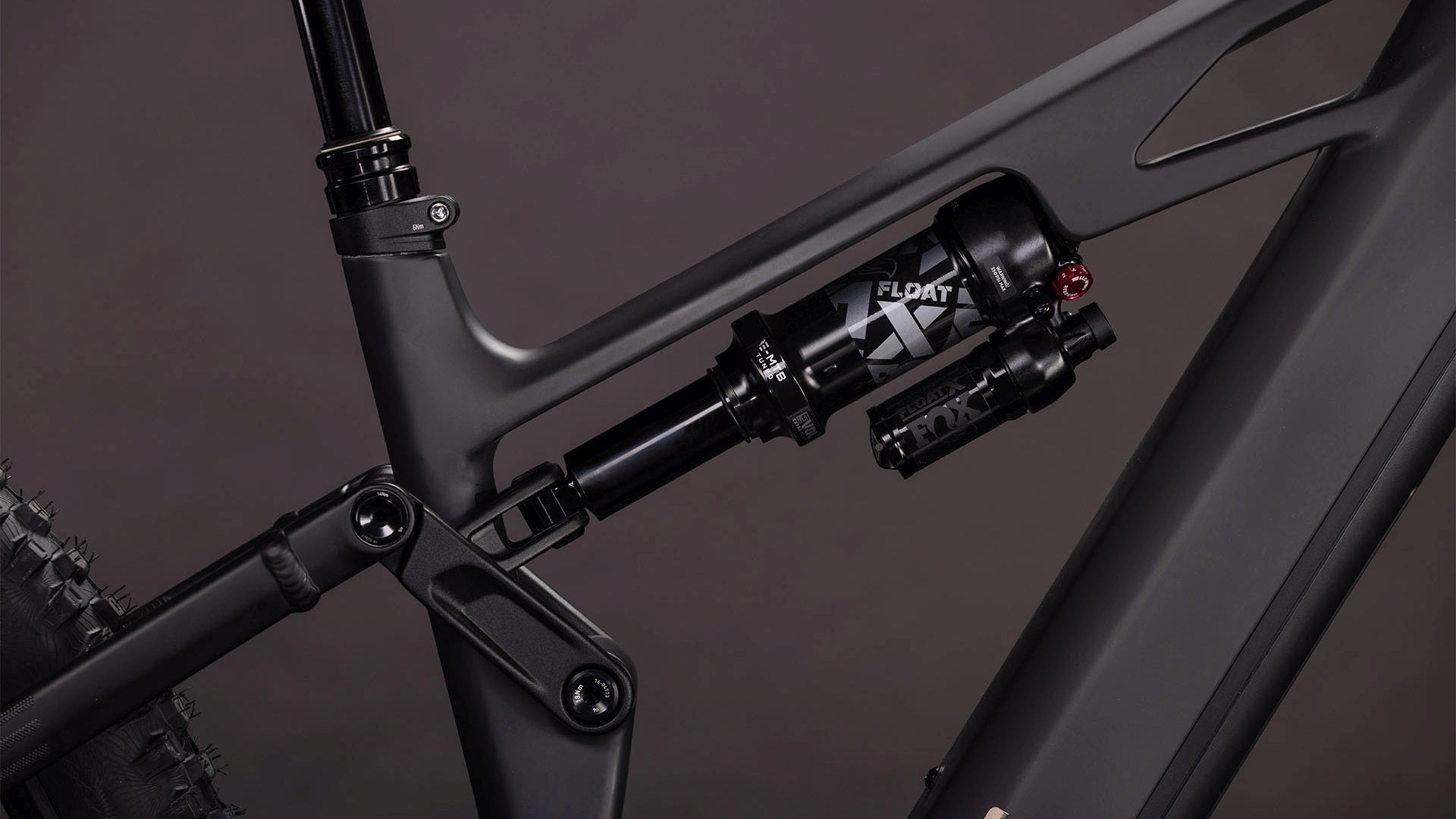 Nahaufnahme der Hinterradfederung des CUBE Stereo Hybrid ONE77 HPC SLX 800 blackline 2026 mit FOX Float X Dämpfer und detaillierter Anlenkung an einem mattschwarzen Rahmen, angetrieben von einem Bosch CX Motor für leistungsstarkes E-Mountainbiking.