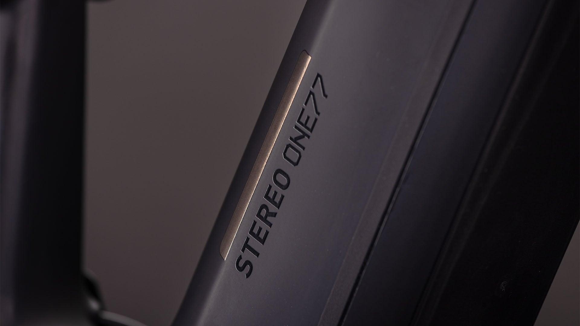 Nahaufnahme eines mattschwarzen CUBE Stereo Hybrid ONE77 HPC SLX 800-Rahmens mit fettem "STEREO ONE77"-Schriftzug, der das Fox Float 38 Rhythm-Fahrwerk hervorhebt.