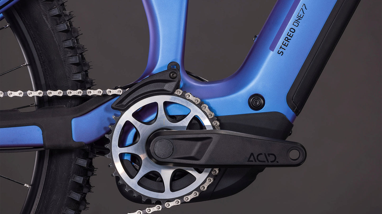Nahaufnahme eines blauen CUBE Stereo Hybrid ONE77 HPC SLX 800 Rahmens mit Bosch CX Motor, ACID Kurbelarm, Kettenblatt, Hinterradreifen und Modellbezeichnung.