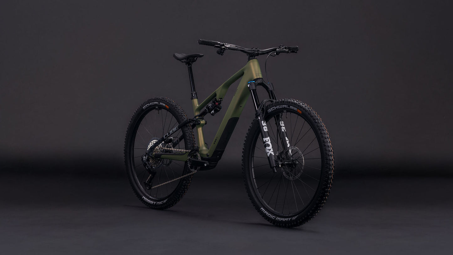 Das CUBE AMS Hybrid ONE44 C:68X TM 400X reedgreen'n'matrix 2026, ein mattgrünes, vollgefedertes Mountainbike mit Fox Fahrwerk und schwarzen Komponenten, ist vor einem dunklen Hintergrund abgebildet, der die dicken Reifen und den stabilen Rahmen hervorhebt.