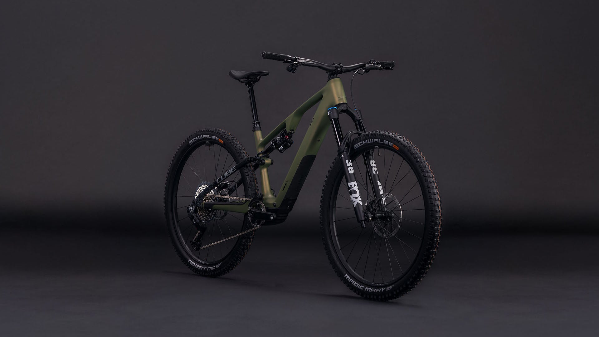 Das CUBE AMS Hybrid ONE44 C:68X TM 400X reedgreen'n'matrix 2026, ein mattgrünes, vollgefedertes Mountainbike mit Fox Fahrwerk und schwarzen Komponenten, ist vor einem dunklen Hintergrund abgebildet, der die dicken Reifen und den stabilen Rahmen hervorhebt.