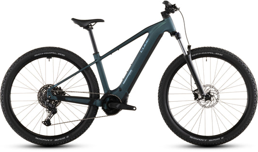 Ein CUBE Reaction Hybrid ONE 800 royalgreen'n'prism 2026 Elektro-Mountainbike mit schlankem Rahmen, Federgabel, dicken Stollenreifen und einem Bosch-Motor (800 Wh Akku), fotografiert von der Seite auf weißem Hintergrund.