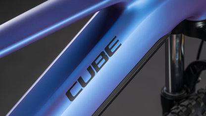 Nahaufnahme des CUBE Reaction Hybrid ONE 800 blueiris'n'reflect 2026, die den metallisch blauen Rahmen mit CUBE-Branding, den Bosch-Motor und einen Teil der vorderen Federgabel und der Reifen im Hintergrund zeigt.