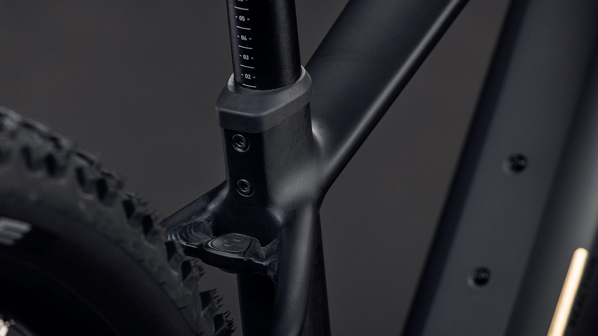 Die Nahaufnahme des CUBE Reaction Hybrid Pro 800 blackline 2026 zeigt den mattschwarzen Rahmen, die Sattelstütze und den hinteren Noppenreifen. Zur Ausstattung gehören ein 800-Wh-Akku und ein leistungsstarker Bosch CX-Antrieb, alles vor einem dunklen Hintergrund.