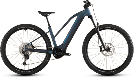 Das CUBE Reaction Hybrid Pro 800 nebular'n'dazzle Trapeze 2026 E-Mountainbike verfügt über einen dunkelblauen Rahmen, einen Bosch CX-Antrieb, eine Vorderradaufhängung, Scheibenbremsen, breite Stollenreifen und einen integrierten 800-Wh-Akku im Unterrohr, der seitlich vor einem weißen Hintergrund abgebildet ist.