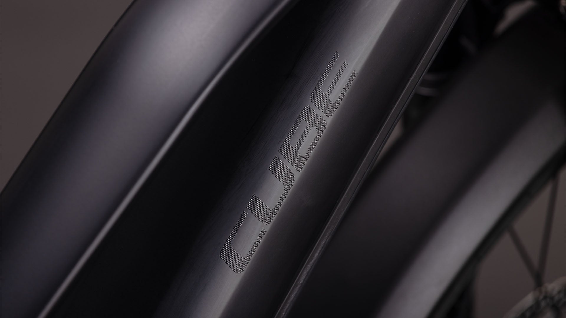 Nahaufnahme des CUBE Reaction Hybrid Pro 800 FE blackline Der mattschwarze Rahmen des Trapeze 2026 zeichnet sich durch ein dezentes Branding und schlanke Konturen aus. Die Beleuchtung betont die glatte Oberfläche und den leistungsstarken Bosch CX-Motor.
