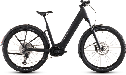 Das CUBE Reaction Hybrid Pro 800 FE blackline Easy Entry 2026 ist ein mattschwarzes E-Bike mit einem Step-Through-Rahmen, breiten Noppenreifen, Vorderradfederung, Scheibenbremsen, Gepäckträger, Schutzblechen und einem Bosch CX-Motor in der Seitenansicht auf Weiß.
