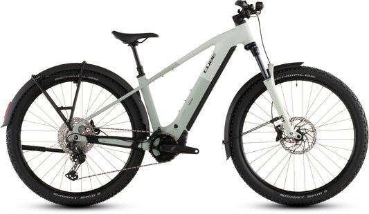 Das CUBE Reaction Hybrid Pro 800 FE desertstone'n'driedherbs 2026 ist ein modernes E-Bike mit dicken schwarzen Reifen, Vorderradaufhängung, Scheibenbremsen, Shimano XT-Schaltung, Schutzblechen und einem Bosch CX-Motor, hier im Profil auf weißem Hintergrund.
