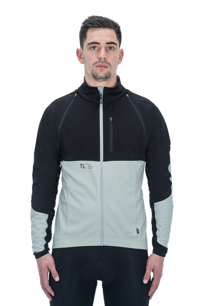 Ein Mann, der die CUBE TEAMLINE Multifunktionsjacke black'n'grey mit abnehmbarem Ärmel und hohem Kragen trägt, steht mit dem Gesicht nach vorne vor einem weißen Hintergrund. Die CUBE Jacke ist wind- und wasserabweisend für vielseitigen Schutz.
