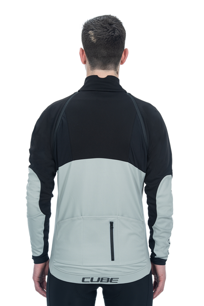 Eine Person wird von hinten gezeigt, die eine CUBE TEAMLINE Multifunktionsjacke black'n'grey von CUBE trägt, mit Reißverschlusstasche, abnehmbarem Ärmel, und dem CUBE Logo auf dem unteren Rücken.
