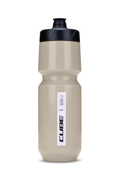 Die Cube CUBE Trinkflasche Flow 750 ist eine beigefarbene Sport-Trinkflasche mit schwarzem Verschluss und "CUBE"-Etikett, das aufrecht auf weißem Hintergrund abgebildet ist. Erhältlich im CUBE Store Hildesheim.