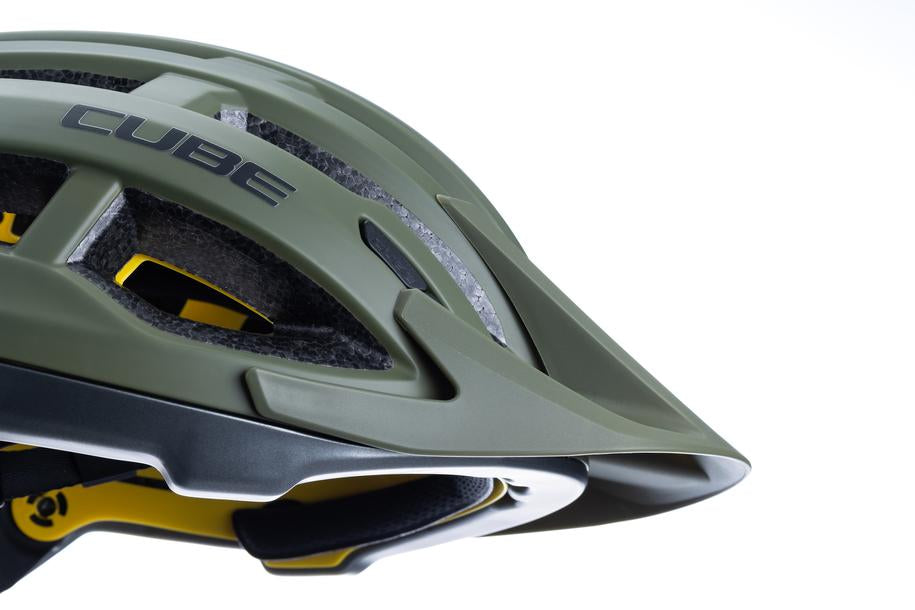 Nahaufnahme eines grünen CUBE Helm OFFPATH MTB-Rennhelms von Cube mit MIPS-Integration, mattem Finish, schwarzer und gelber Polsterung und hervorstehendem Visier vor weißem Hintergrund.