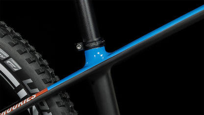 Nahaufnahme des CUBE Elite 240 C:62 Pro carbon'n'blue'n'red 2024 Rahmens von CUBE. Hervorzuheben sind das blau-schwarze Sitzrohr, die Sattelstütze und ein Noppenreifen mit sichtbarem Profil vor schwarzem Hintergrund.