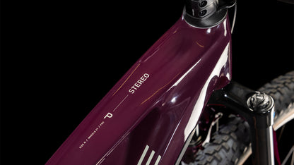 Nahaufnahme des CUBE Stereo Hybrid ONE22 Pro 800 amarone'n'grey 2025 Rahmens mit dem STEREO Label auf dem Oberrohr. Der schwarze Lenker und ein Teil des Vorderradreifens sind zu sehen, der Bosch CX-Antrieb steht vor einem schwarzen Hintergrund.