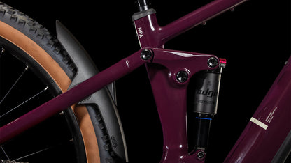 Nahaufnahme des CUBE Stereo Hybrid ONE22 Pro 800 amarone'n'grey 2025-Rahmens mit Hinterradfederung, Magura MT Thirty-Scheibenbremsen, hinterem Schutzblech, hellbraunem Hinterradreifen und detaillierter Mechanik vor schwarzem Hintergrund.