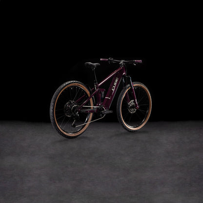 Das CUBE Stereo Hybrid ONE22 Pro 800 amarone'n'grey 2025 steht auf einer dunklen, strukturierten Oberfläche vor schwarzem Hintergrund, angewinkelt, um seinen Rahmen und Shimano Cues 10-fach Schaltung für präzise Schaltvorgänge zu präsentieren.
