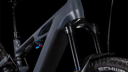 Nahaufnahme des mattgrauen CUBE Stereo Hybrid ONE77 HPC Race 800 (2025) Rahmens mit Federgabel, Stoßdämpfer und Schwalbe-Vorderradreifen vor schwarzem Hintergrund.